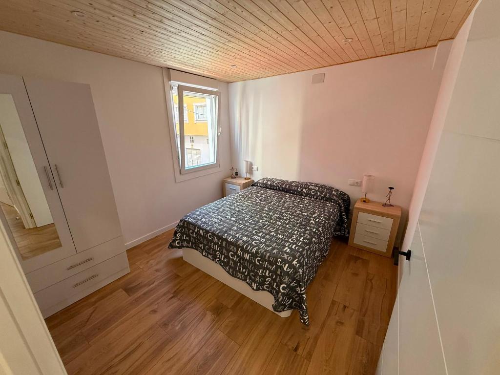 a small bedroom with a bed and a window at Agasallo Cedeira in Cedeira