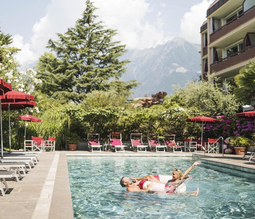 a woman in a swimming pool at a hotel at Hotel Gartenresidence Zea Curtis in Merano