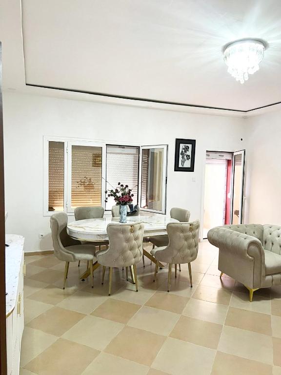 a dining room with a table and chairs at Le balcon bleu in Oran
