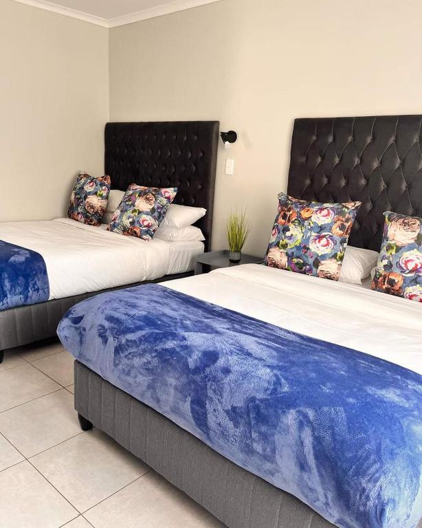 two beds sitting next to each other in a room at Blooming Rose Bed and Breakfast in Polokwane