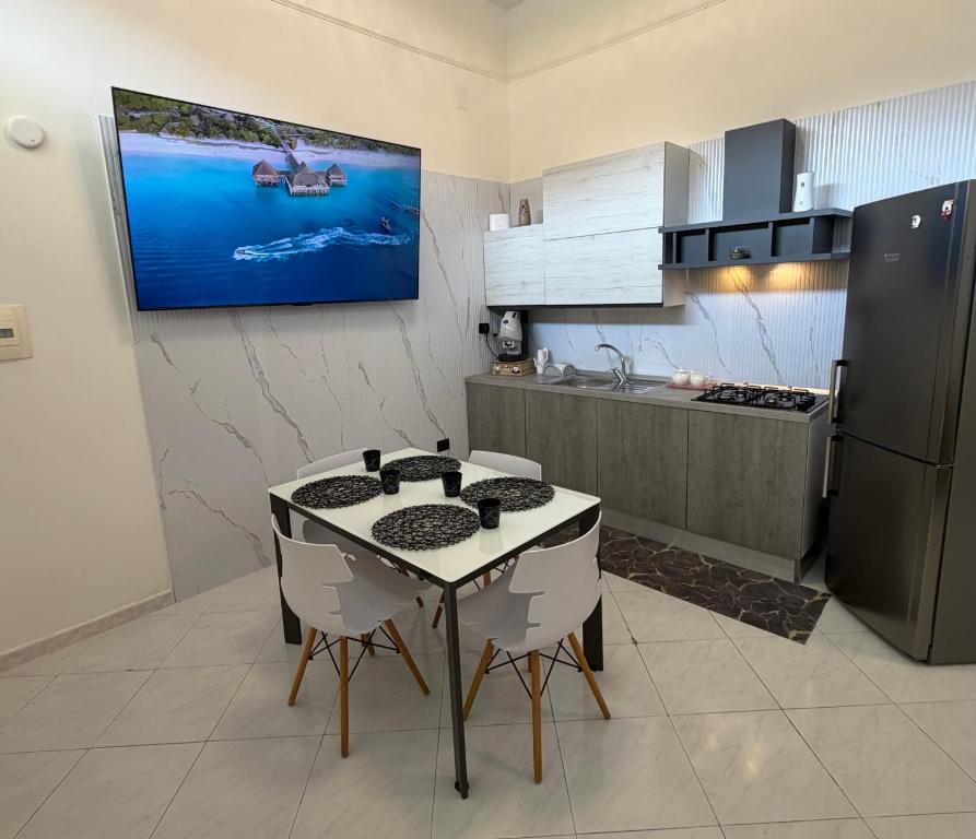 a kitchen with a table and a tv on the wall at Vittoria & Celeste in Cervino