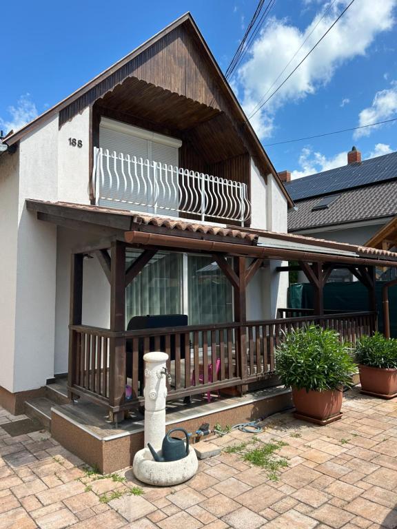 a house with a porch with a wooden deck at PEP Apartman in Balatonlelle