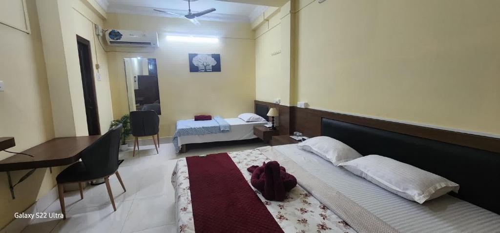 a bedroom with a large bed and a desk and a room with a bedicter at Hotel Roy's in Shādipur