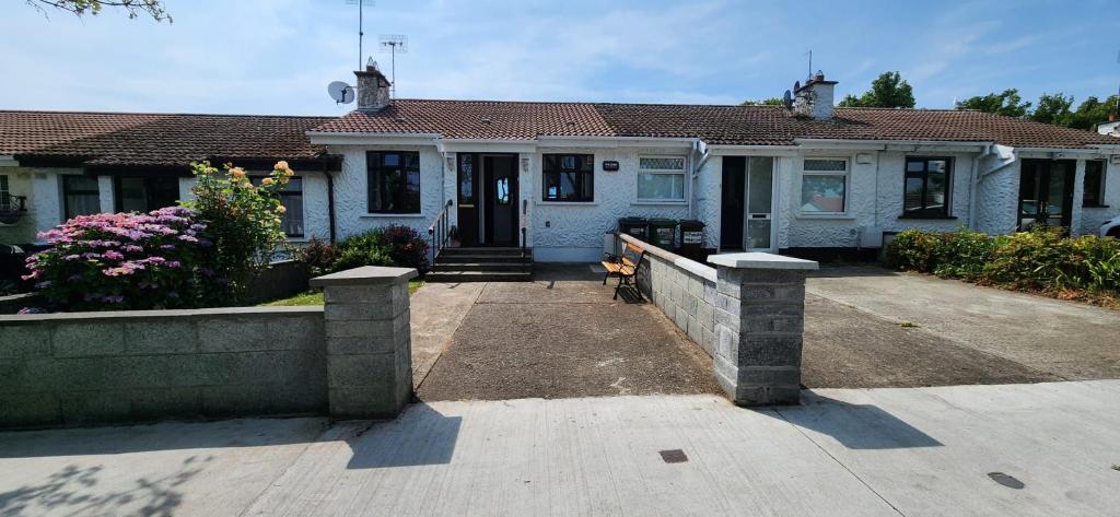 a house with a dog sitting in front of it at Cosy Bungalow in Balbriggan