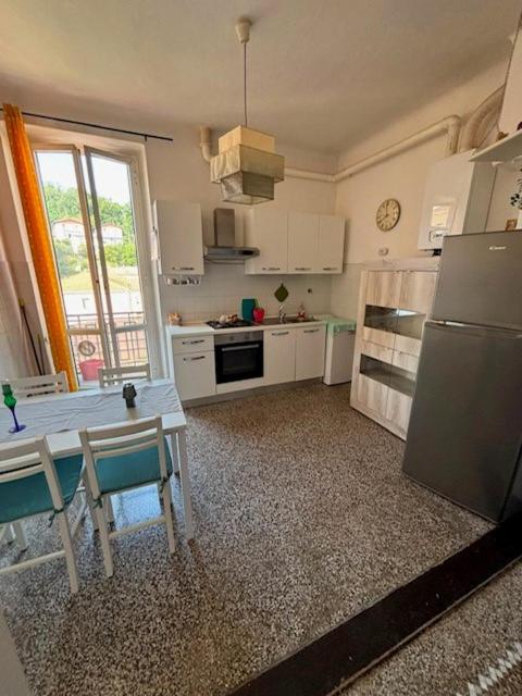 eine Küche mit einem Tisch und einem Kühlschrank in der Unterkunft Corso Martiri in Cairo Montenotte