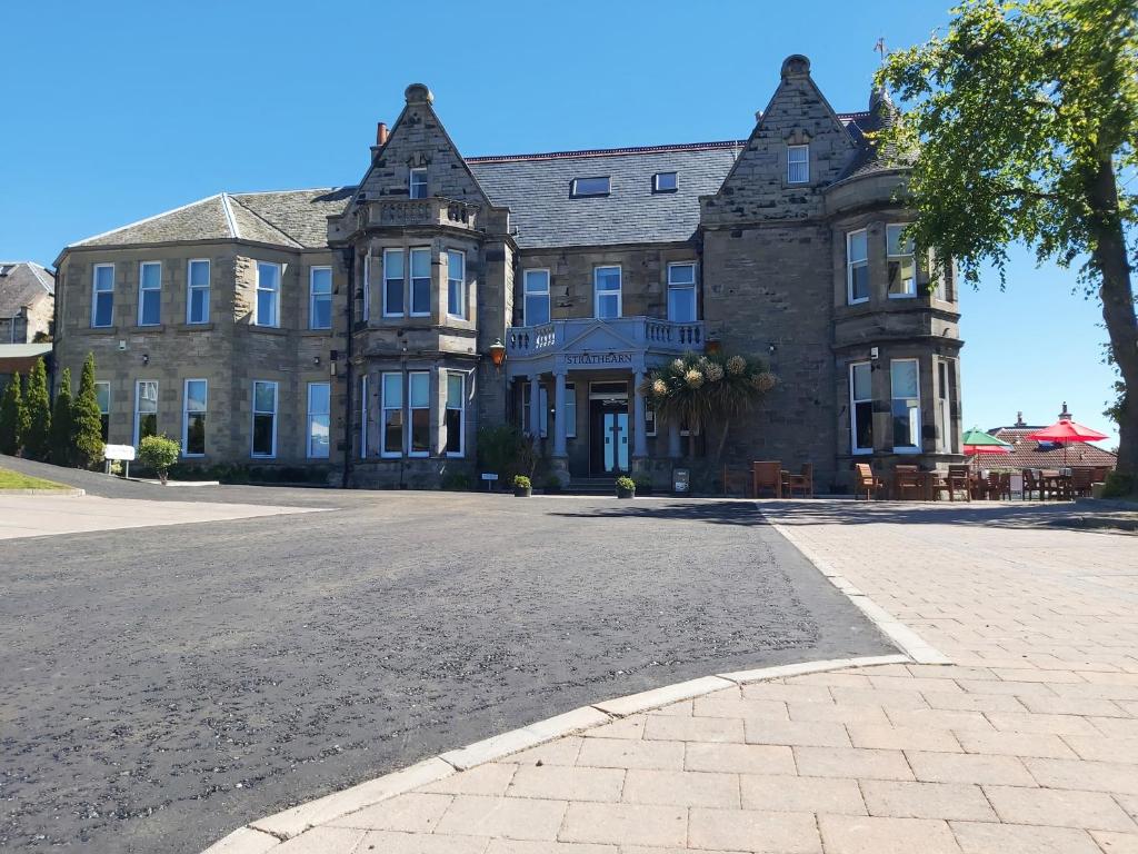 a large stone building with a street in front of it at The Strathearn Hotel in Fife