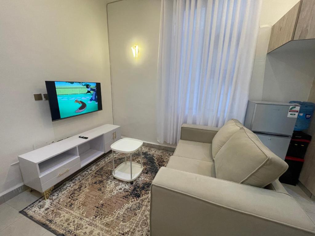 a living room with a couch and a flat screen tv at Tulia, Anchor in Ruaka
