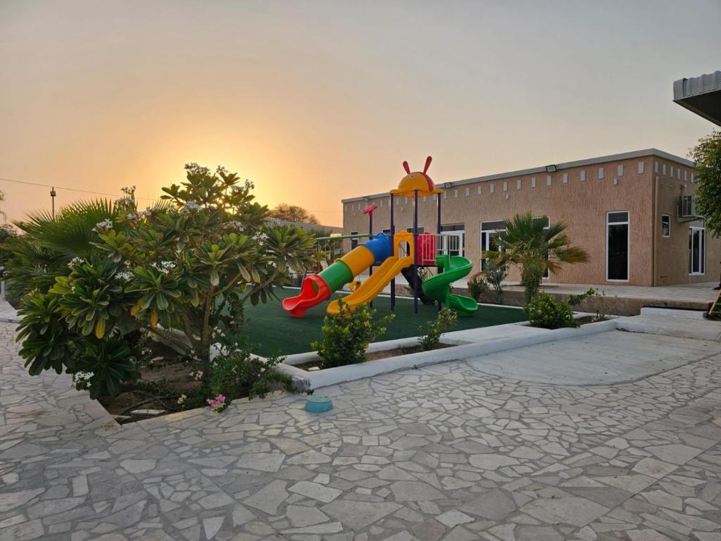a playground with a slide in front of a building at مزرعه فلج فارم Falaj-farm in Falaj al Mu‘allá