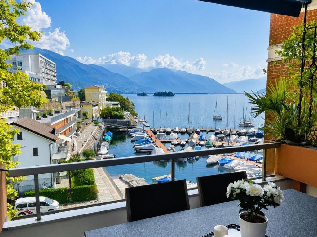 a balcony with a view of a marina at Dolce Vita by Fewotessin in Brissago