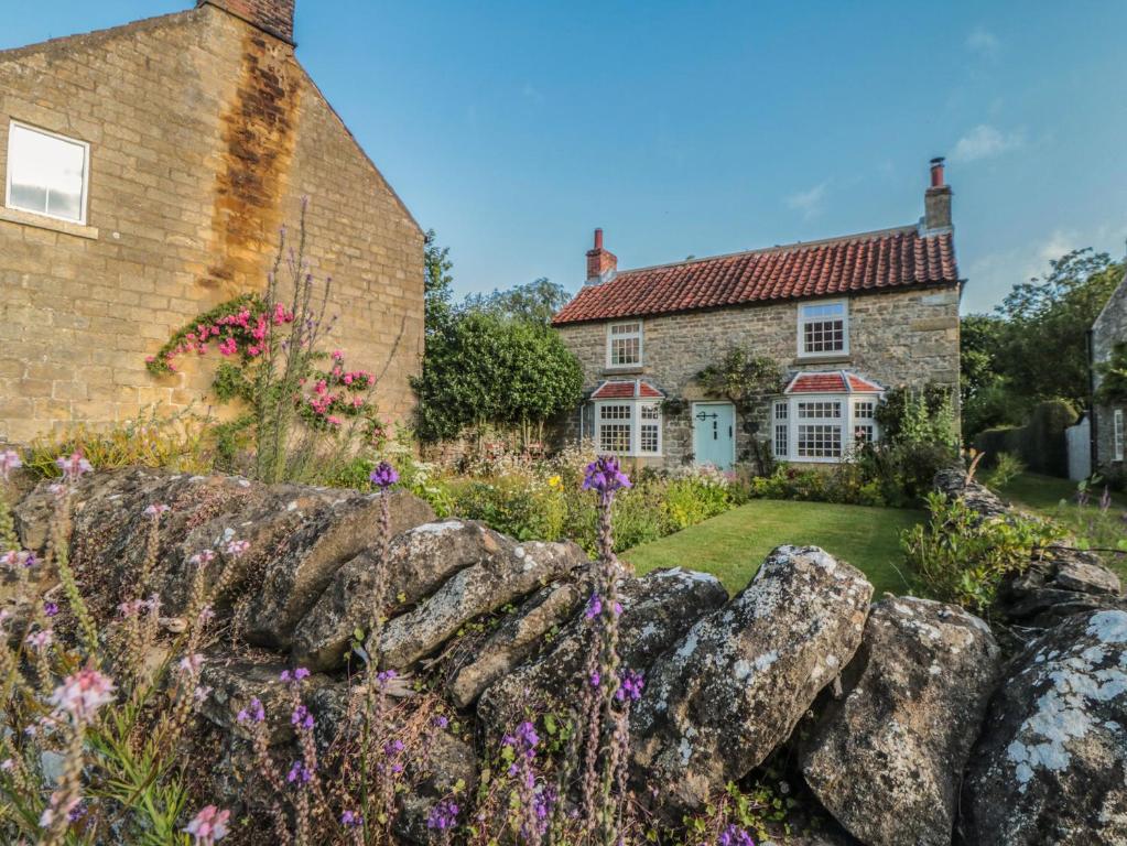 a cottage with flowers in front of it at Bute Cottage in Pickering