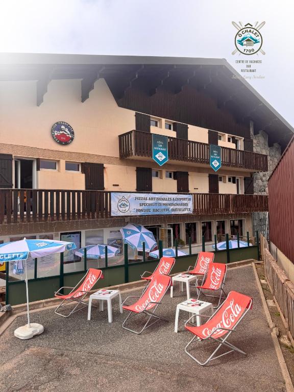 a group of chairs and umbrellas in front of a hotel at Ô Chalet 1700 in Saint-Lary-Soulan