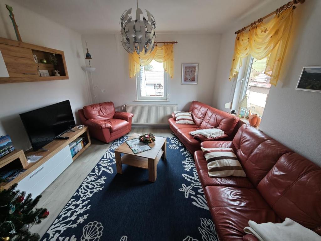 a living room with a leather couch and a coffee table at Ferienwohnung Siegmund Mitte in Waltershausen