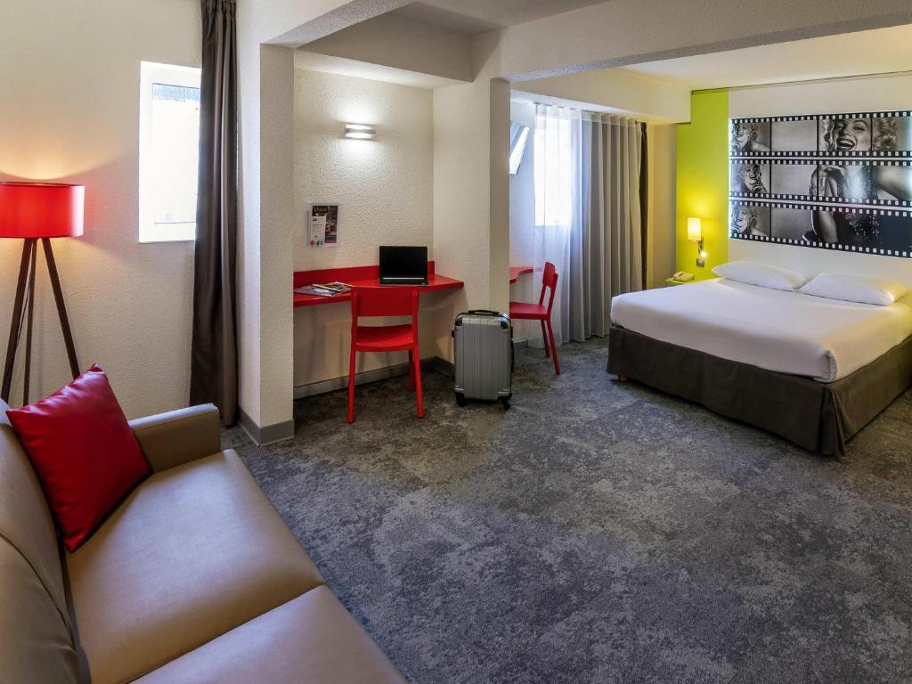 a hotel room with a bed and a desk at ibis Styles Cannes Le Cannet in Cannes
