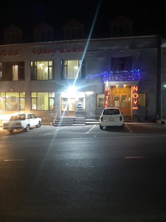 two cars parked in front of a building at night at Noy in Goris
