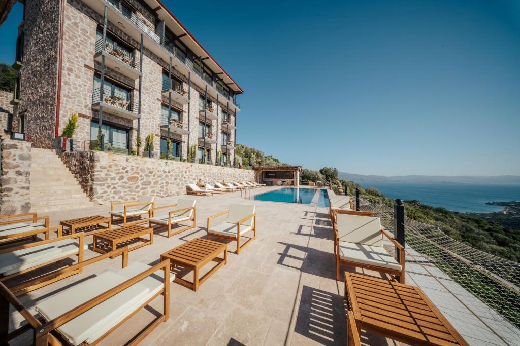 a building with wooden benches and a swimming pool at Serotonin Premium Collection in Balabanlı