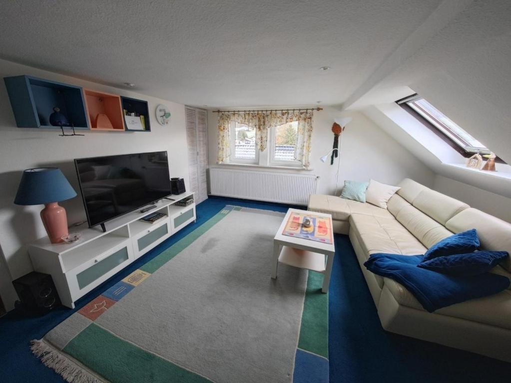 a living room with a couch and a television at Ferienwohnung Siegmund Dachboden in Waltershausen