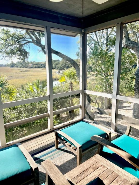 a screened in porch with two chairs and a bench at 1228 Creekwatch Villa in Seabrook Island