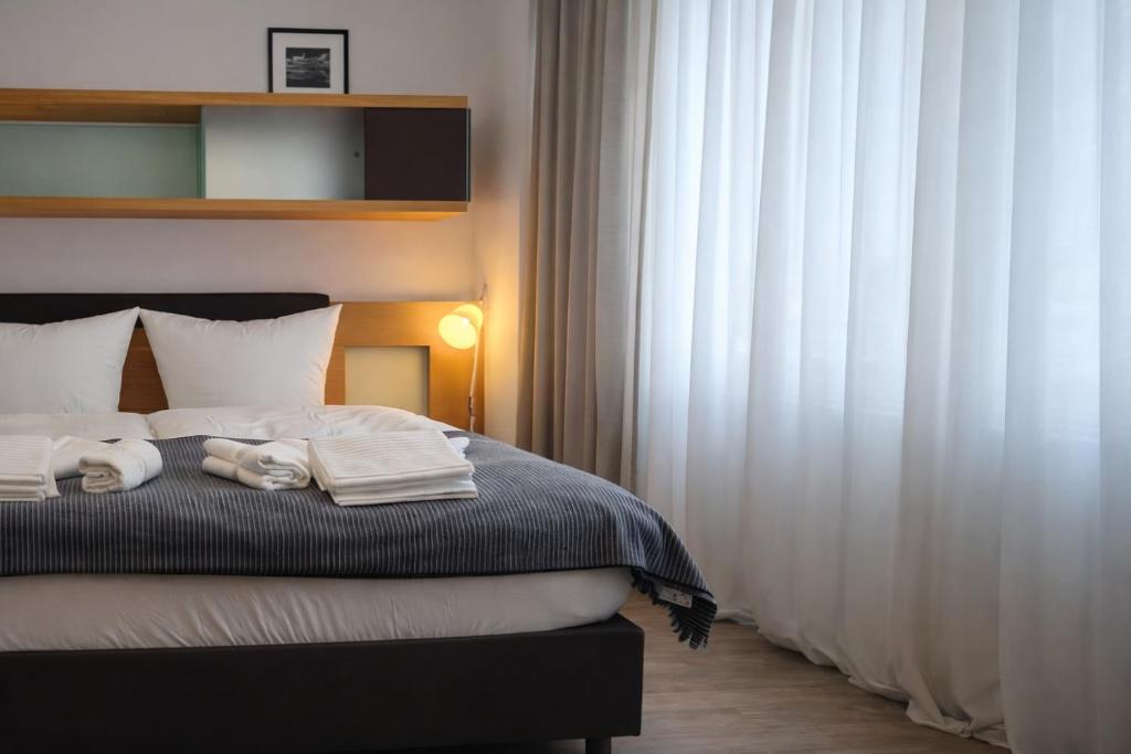 a bedroom with a bed with towels on it at Check-Inn Hotel - free parking in Offenbach