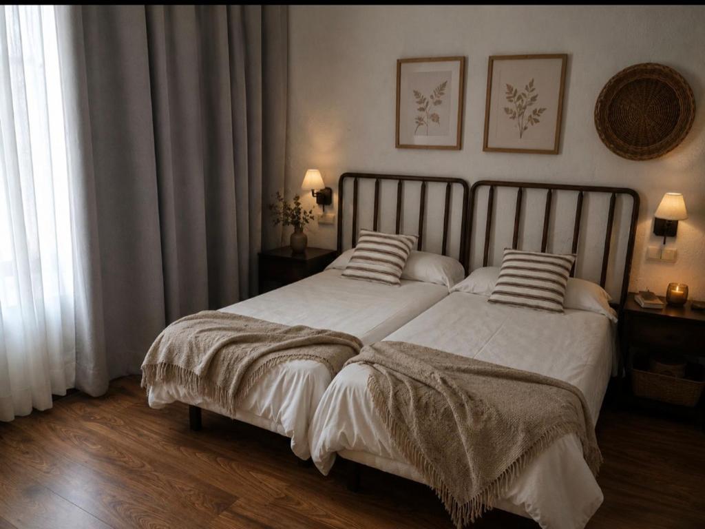 a bedroom with a large bed with white sheets and pillows at El Linar in Burgohondo