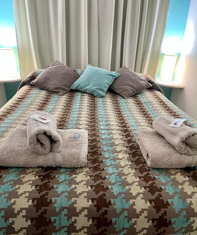 a bed with towels and pillows on it at Apart Hotel RioSol in Concepción del Uruguay