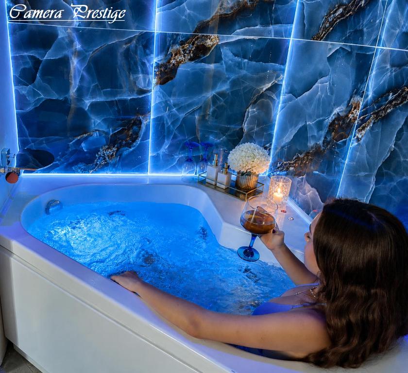 a woman sitting in a bath tub with a candle at Dharma Luxury Room in La Spezia