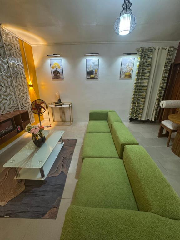 a living room with a green couch and a table at Angevita City2 in Edéa