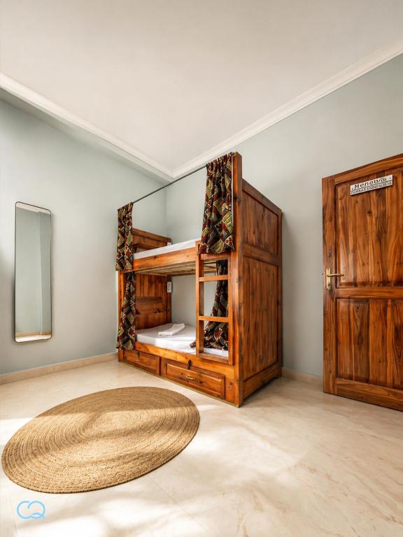 a room with a bunk bed with a mirror at Cozy Quarters in Zanzibar City