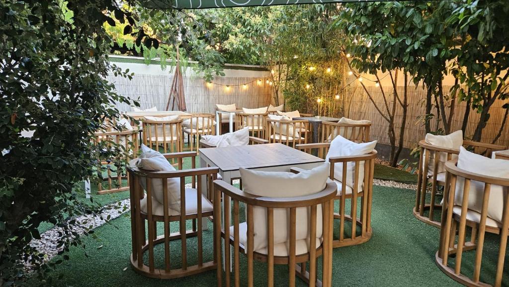 una fila di tavoli e sedie in un giardino di Friday Hotel a Mamaia Nord - Năvodari