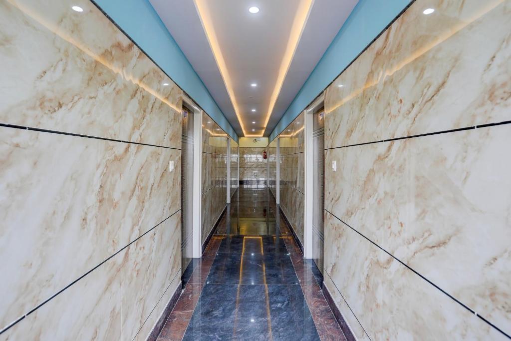 a corridor in a building with marble walls and a ceiling at SPOT ON Sri Chowdeshwari Residency in Chik Bānavar
