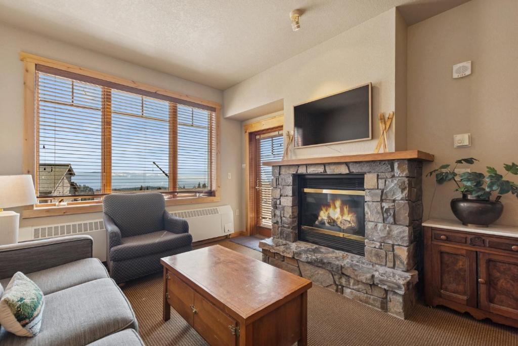 a living room with a fireplace and a tv at Morning Eagle 207 in Whitefish