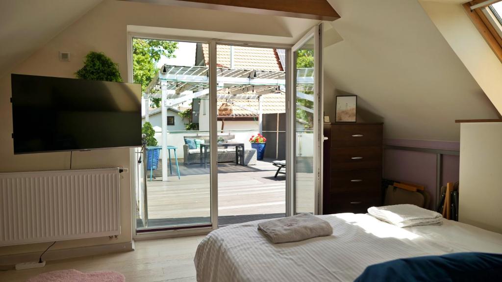 a bedroom with a bed and a sliding glass door at Nadmorska Miła in Gdańsk