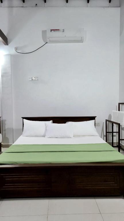 a bed with a green mattress in a room at Emerald Mirror in Anuradhapura