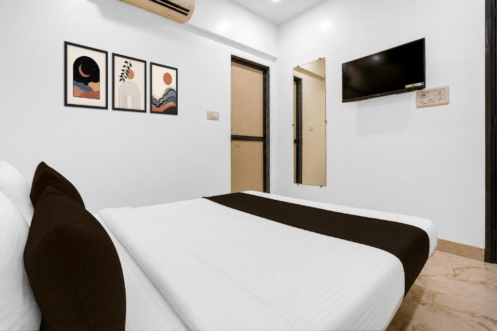 a white bedroom with a bed and a tv at Super Collection O MIDC Mahape Mumbai Formerly Hotel Didar House in Mumbai