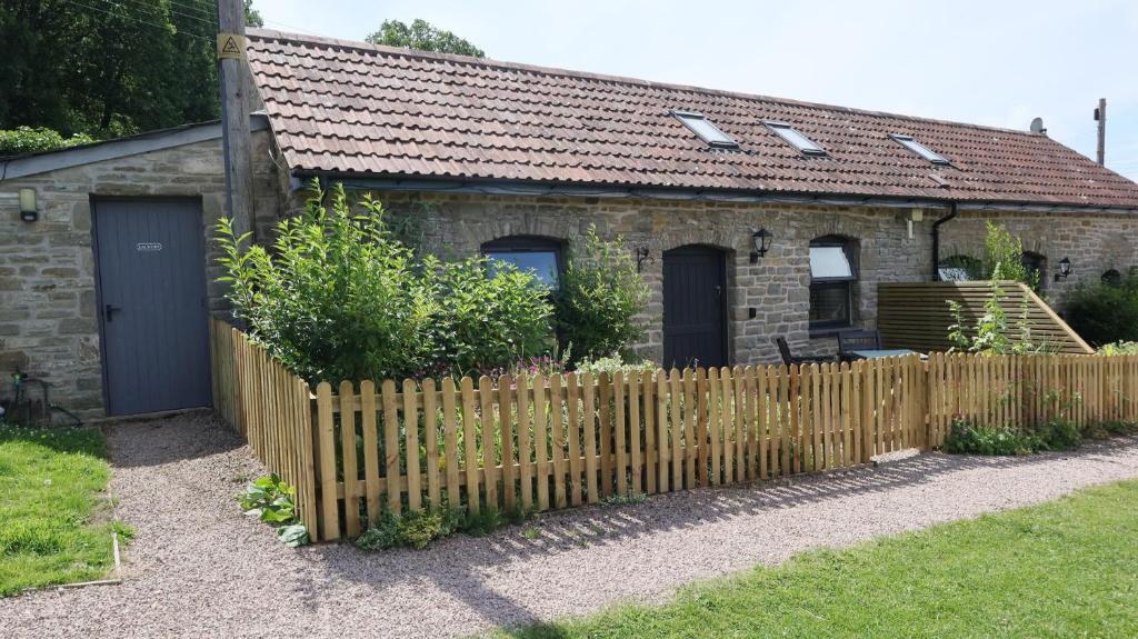 ein Haus mit einem Holzzaun davor in der Unterkunft Castle Rag in Lydney