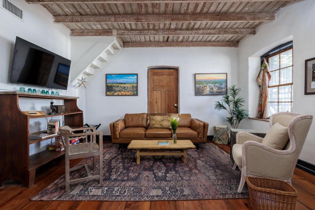 a living room with a couch and a table at Historic Rumpel Kammer - Compound in Fredericksburg