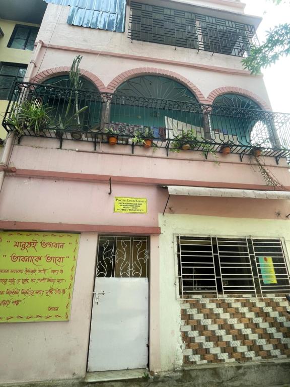 a pink building with a balcony and a door at Peaceful Living in Kolkata