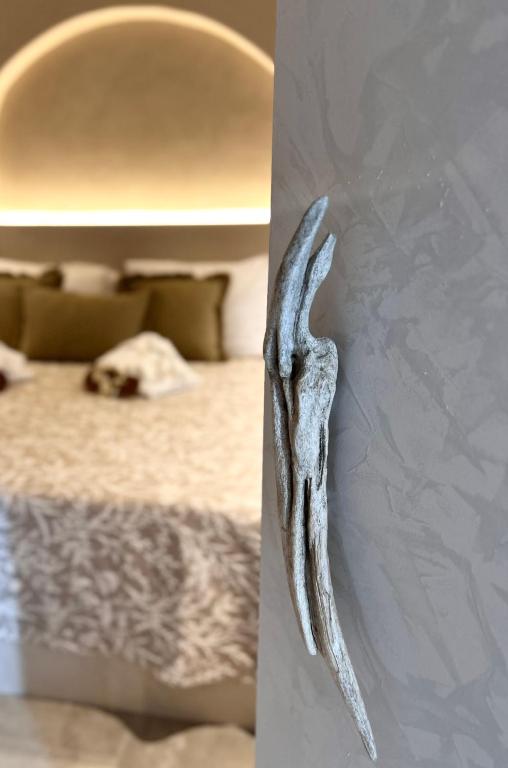 a antler hanging on a wall next to a bed at Calliopes by the sea boutique suites in Paralia Dionysiou