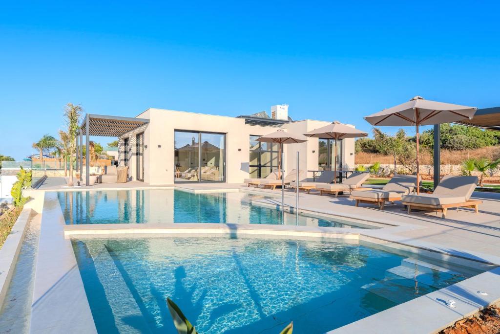 a swimming pool in front of a house at Nysa Luxury villas 3-4-5-6 in Heraklion
