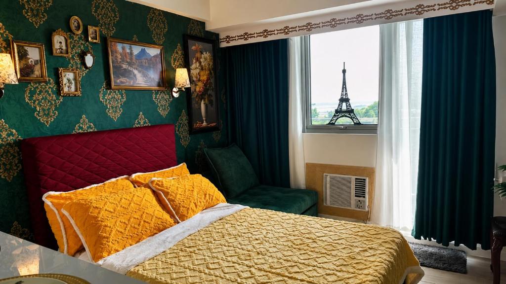 a bedroom with a bed and a window with the eiffel tower at CA Smart Staycation at Azure North in Lagundi
