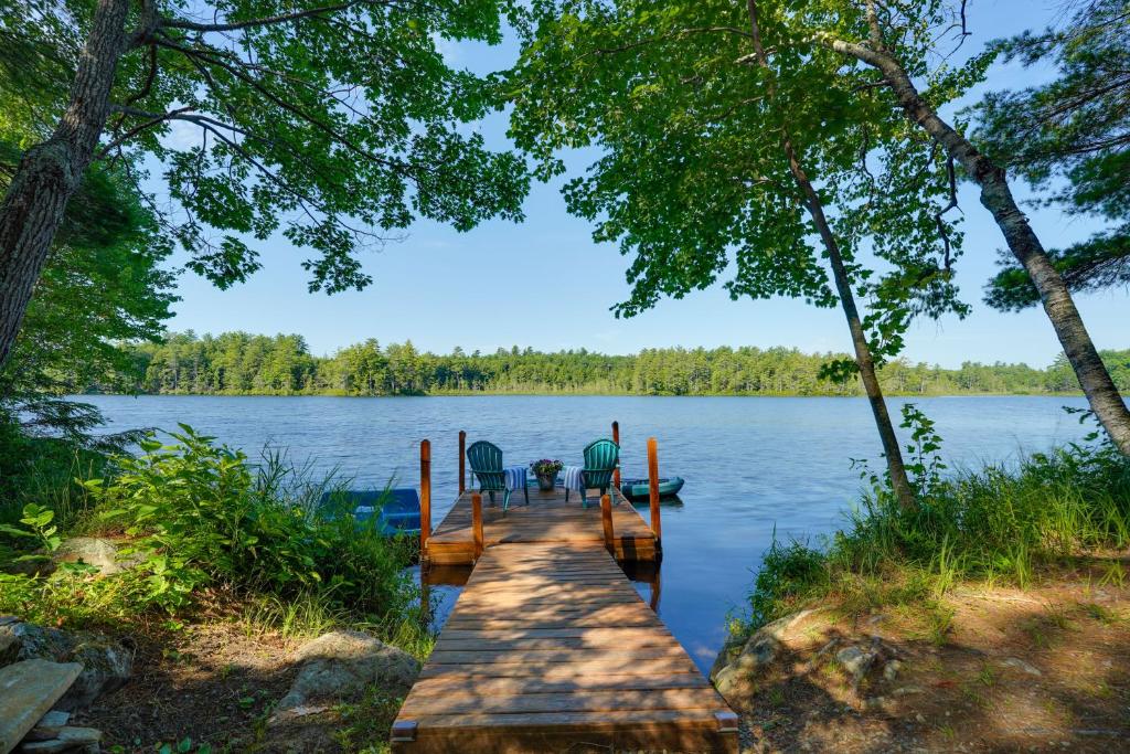 a dock with chairs on it on a lake at Private Dock & Deck: Tranquil Dam Pond Cottage! in Augusta