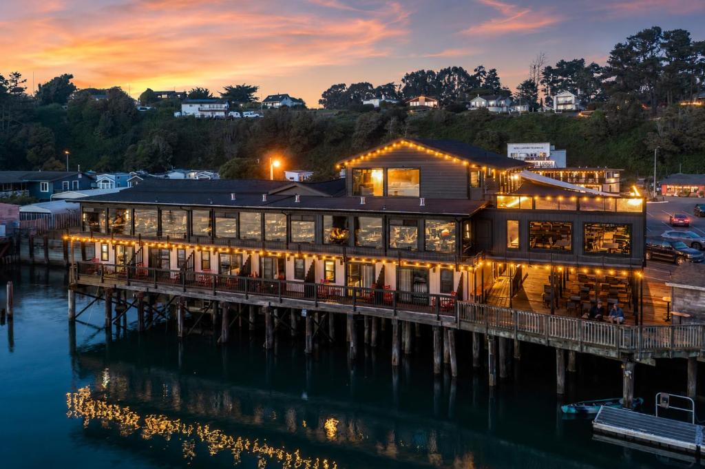 a restaurant on the water at dusk at Anchor Lodge in Fort Bragg