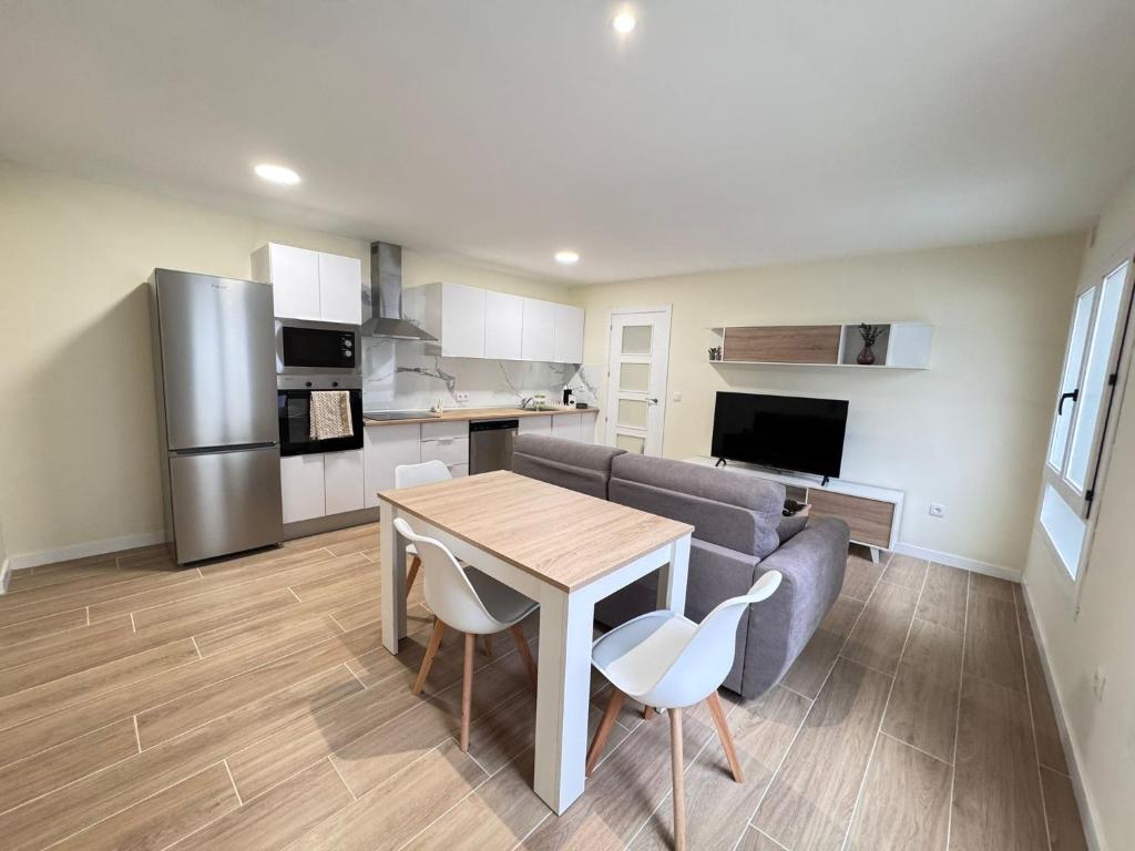 a kitchen and living room with a table and a couch at Residencial Junceda in Viveiro