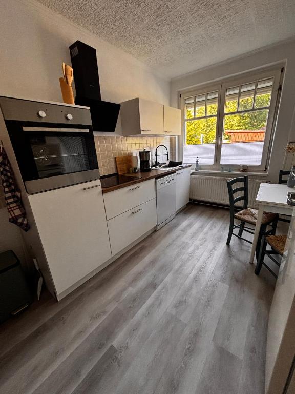 a kitchen with white cabinets and a table with a tableablish at Idylle Ostsee in Buggenhagen