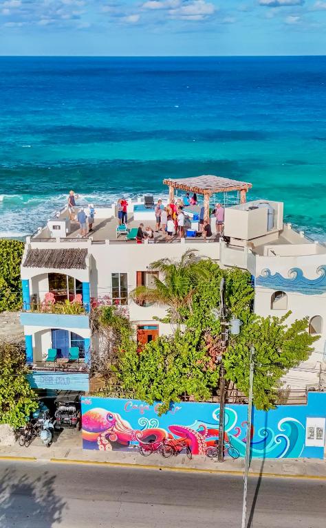 a building on the beach with the ocean in the background at Casa Cielo 2 Bedroom Oceanfront Villa in Isla Mujeres