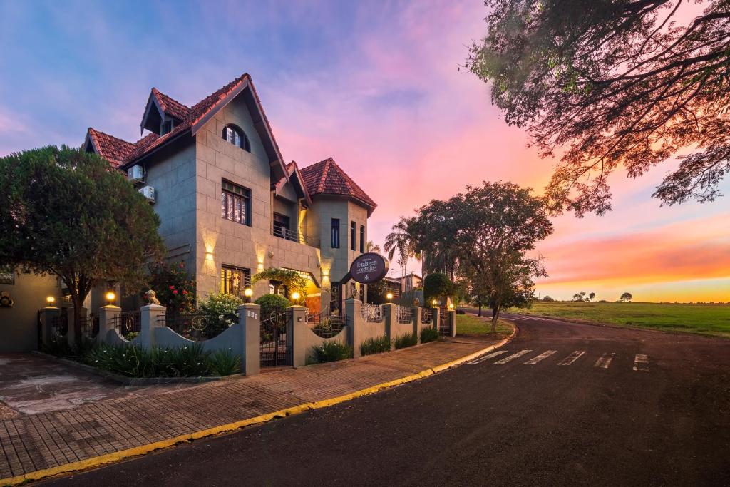a house on the side of a road at sunset at Pousada Estalagem de Brotas in Brotas