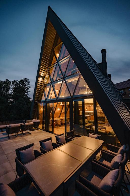 a house with a table and chairs on a patio at The Frame Croatia in Ravna Gora