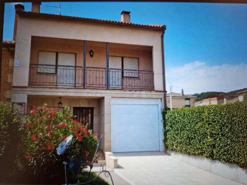 a house with a garage and a fence at Fuenteazul in Hortigüela