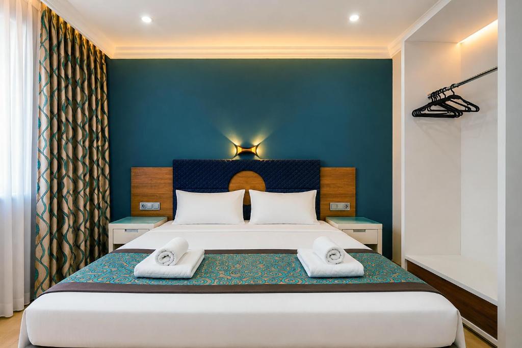 a bedroom with a large bed with two towels on it at Dublin Hotel in Alanya