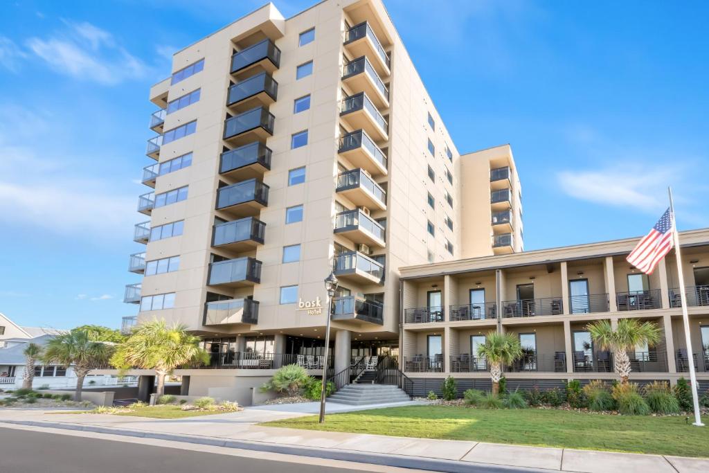 an apartment building with an american flag at Bask Hotel at Big Rock Landing in Morehead City