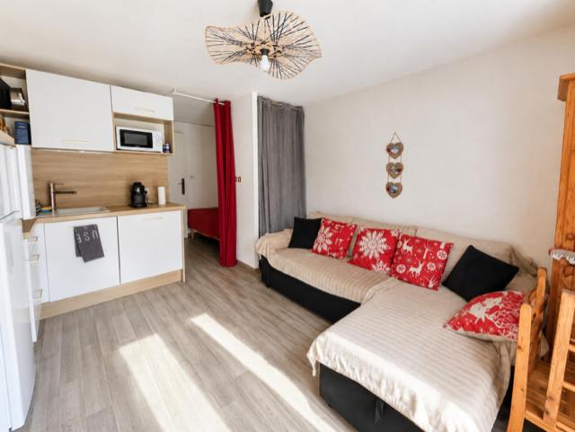 a living room with a couch and a kitchen at Studio à Praz-sur-Arly in Praz-sur-Arly